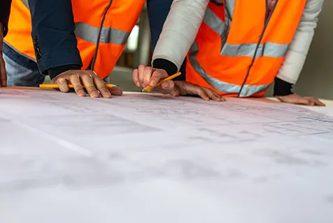 Construction worker pointing at business plans