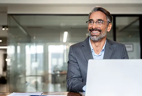 Man smiling off screen on his laptop